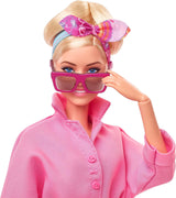 BARBIE LA PELÍCULA Margot Robbie - Puppe mit Kaugummi-Rosa jumpsuit, Messy Updo, Sonnenbrille, Kopftuch, Wedge-Sneakers, Sammlerverpackung, für Kinder ab 3 Jahren, HRF29