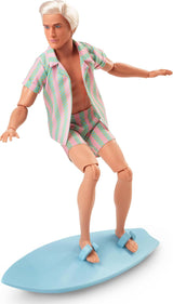 Muñeca Barbie Ken de la película Barbie con ropa de playa a rayas rosa pastel y verde, tabla de surf y zapatillas blancas, JBJ54