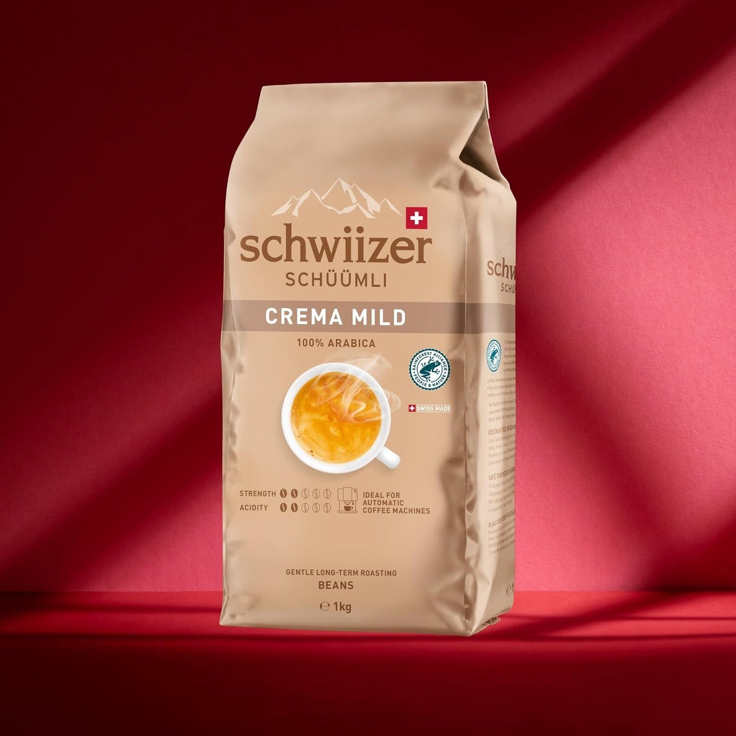 Schwiizer Schüümli Crema Mild, café en grano 100% Arábica fino, armonioso y suave, ideal para máquinas automáticas de espresso, concentración 2/5, tueste ligero, Rainforest Alliance, 1kg