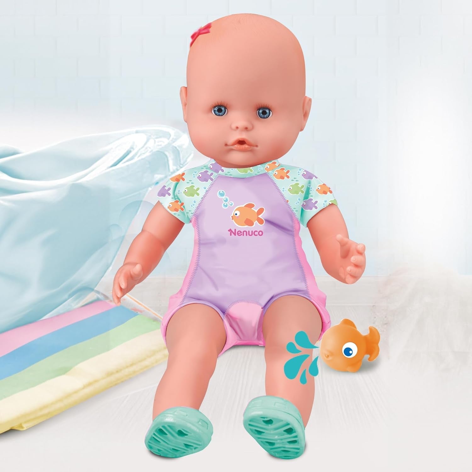 Mi primer baño: Un muñeco blandito con cuerpo impermeable, apto para usar en la bañera, la piscina y el mar. Incluye traje de baño y un pez colocado en el agua.