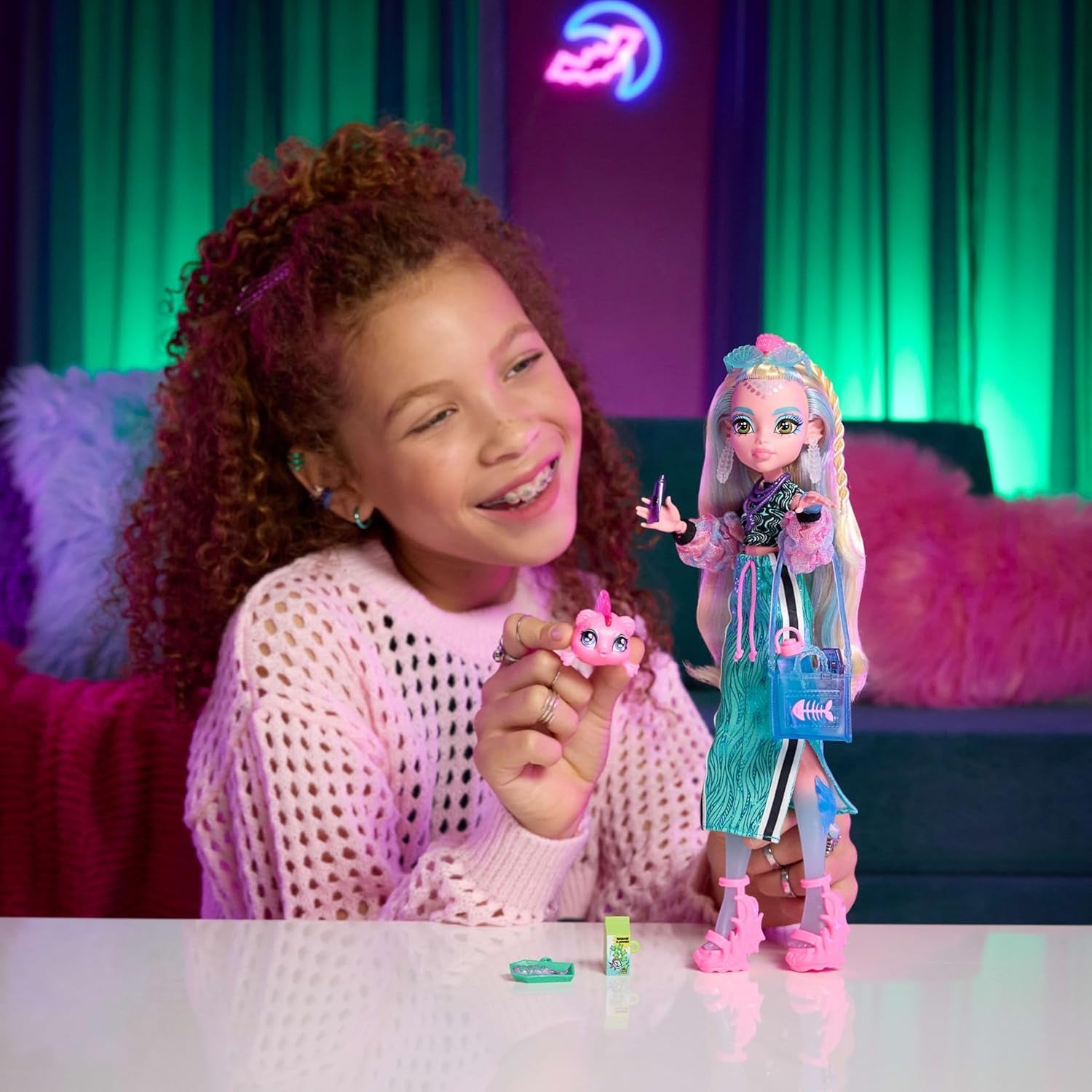 Muñeca Monster High Lagoona Blue Neptuna Fish con top corto y falda larga deportiva con 7 accesorios que incluyen gafas de sol, refrigerio y bolso, JHK33